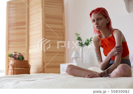 Anorexic woman with tattoos on arms feeling miserable Anorexic woman with tattoos on arms feeling miserable 50830082