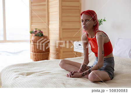 Woman with bulimia sitting on bed feeling bad and lonely Woman with bulimia sitting on bed feeling bad and lonely 50830083