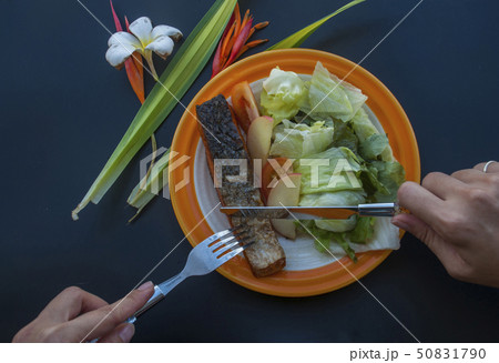 Fish steak with vegetable salad 50831790