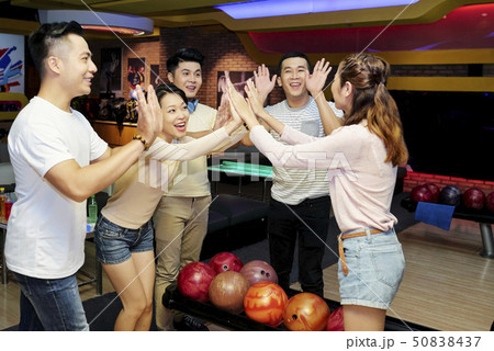 Friends celebrating victory with in bowling center 50838437