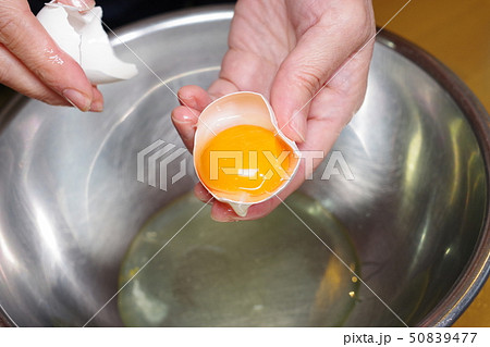 生卵を割っているところ 生卵を割っているところ 50839477