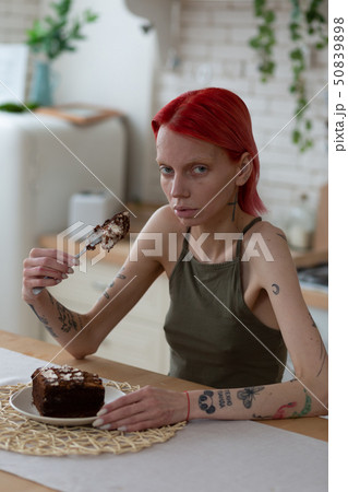 Woman feeling bad after long suffer from bulimia holding cake 50839898