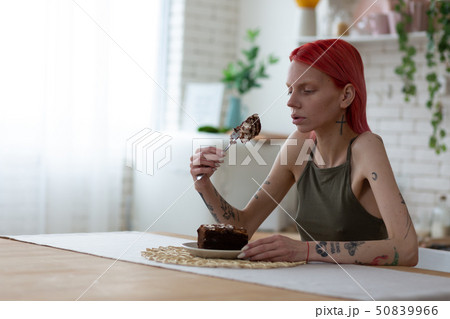 Woman suffering from bulimia having wish to eat cake 50839966