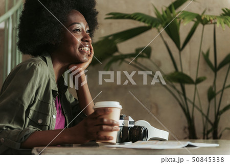 Close up of cheerful young African woman having rest in cafeteria Close up of cheerful young African woman having rest in cafeteria 50845338