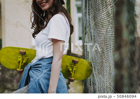 Young trendy hipster girl with yellow skateboard 50846094