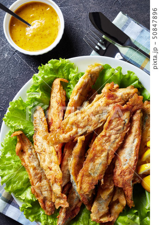 Fried small capelins on a white plate 50847896