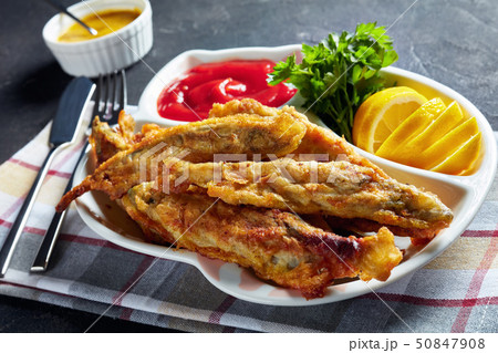 Fried in batter capelins on a plate, close-up 50847908