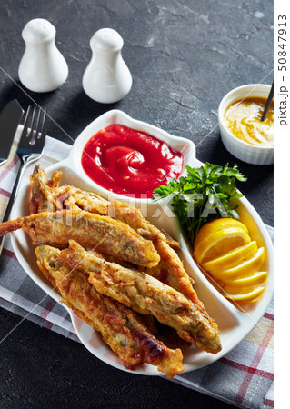 Fried small capelins with tomato sauce, top view 50847913