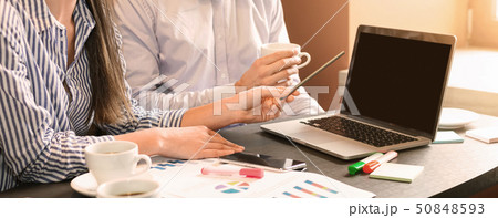 Colleagues analyzing statistics and strategy on laptop 50848593