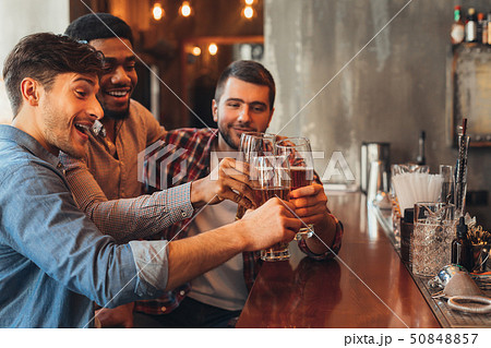 Male Friends Drinking Beer And Talking In Bar Male Friends Drinking Beer And Talking In Bar 50848857