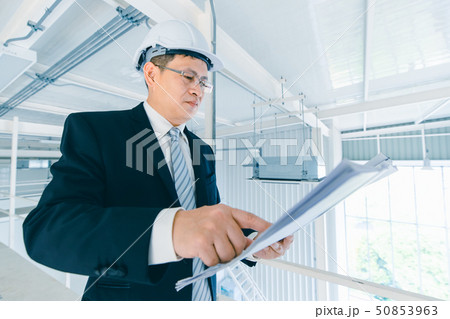 Asian executive engineer checks blueprint.. Asian executive engineer checks blueprint.. 50853963