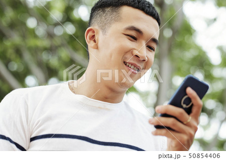 Cheerful texting young man 50854406