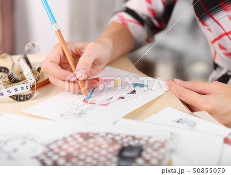 Dressmaker is drawing a fashion sketch 50855079