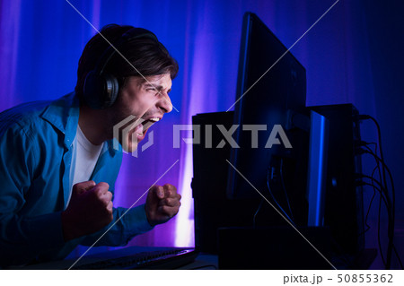 Professional Gamer Playing and Winning in Shooter Online Video Game 50855362