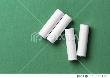 white batteries on a green background white batteries on a green background 50856130