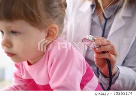 Female doctor arm hold stethoscope measuring patient heartbeat Female doctor arm hold stethoscope measuring patient heartbeat 50865174