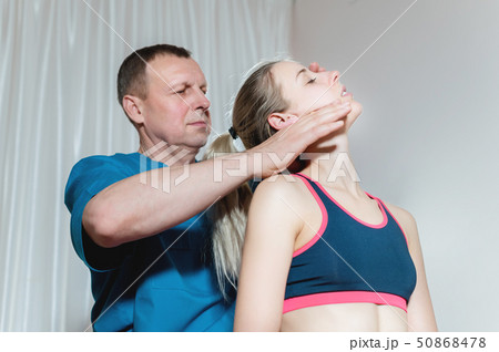 Male manual visceral therapist masseur treats a young female patient. Editing neck and vertebrae 50868478