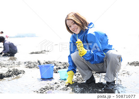 潮干狩りを楽しむ若い女性の写真素材