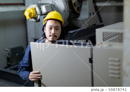 Young Asian engineer use notebook seting to machinery.. Young Asian engineer use notebook seting to machinery.. 50878741