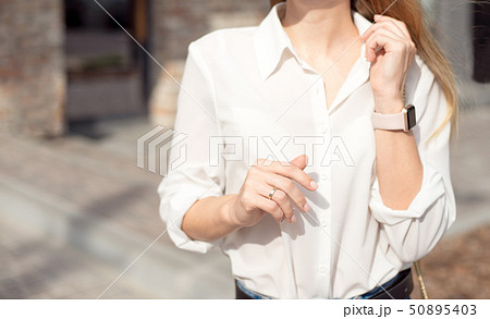 Portrait of a successful happy business woman in a white shirt and sunglasses. Smart watch on a hand Portrait of a successful happy business woman in a white shirt and sunglasses. Smart watch on a hand 50895403