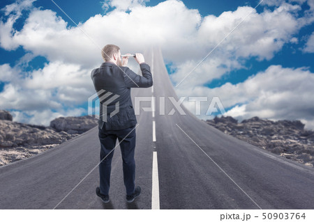 Businessman standing on road that goes up to the sky Businessman standing on road that goes up to the sky 50903764