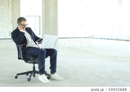 Young businessman with laptop in the big hall 50932688