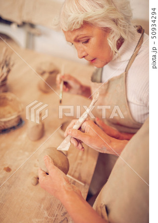 Top view of a clay piece in male hands 50934294