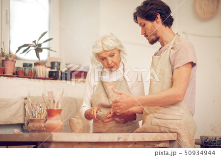 Pleasant young man asking a question to the teacher 50934944