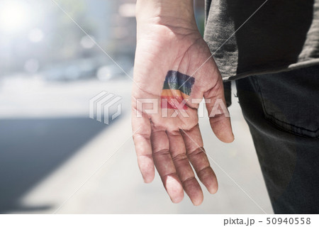 person with a rainbow flag in his or her hand. person with a rainbow flag in his or her hand. 50940558