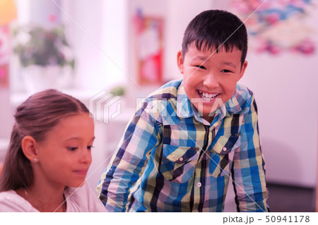 Laughing boy standing near his sitting classmate. Laughing boy standing near his sitting classmate. 50941178