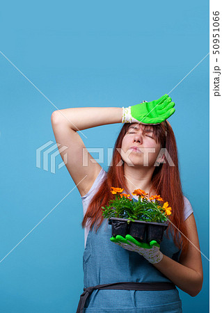 Photo of tired brunette girl with marigolds in her hands 50951066
