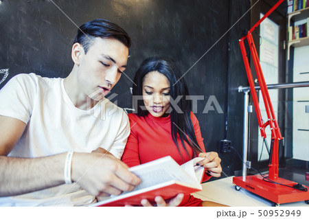 couple students in univercity library, looking book, preparing to exam, having fun, making selfie 50952949