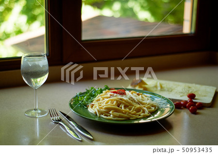 Pasta Carbonara with grated Parmesan cheese and cherry tomatoes, decorated with arugula.Italian 50953435