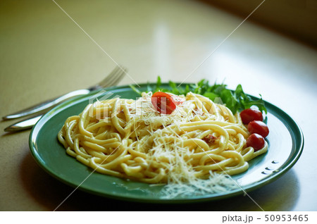 Pasta Carbonara with grated Parmesan cheese and cherry tomatoes, decorated with arugula.Italian 50953465