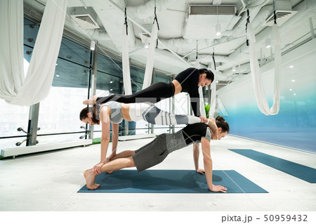 Strong people practicing fitness yoga doing planks on the backs 50959432