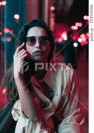 Night in the city, beautiful woman among red lights. 50959686