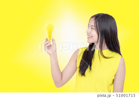 young woman holding yellow light bulb. 51001715