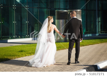 gorgeous bride and groom walking near the modern building 51017271