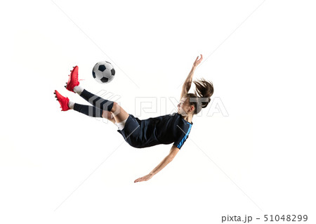 Female soccer player kicking ball isolated over white background 51048299