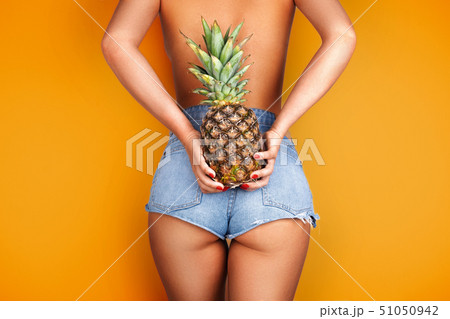 Young woman holding a pineapple in her hand. Young woman holding a pineapple in her hand. 51050942