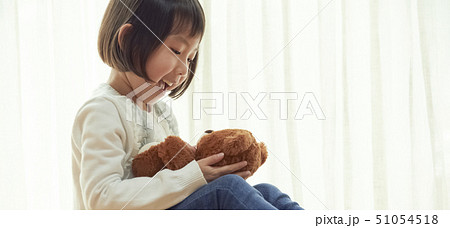 床に座り小さなクマと遊ぶ女の子 51054518