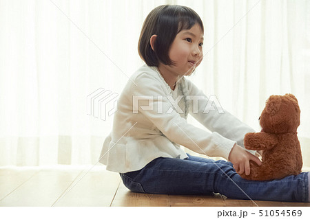 床に座り小さなクマと遊ぶ女の子 51054569