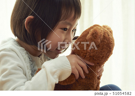 床に座り小さなクマと遊ぶ女の子 51054582