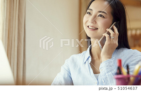 リビングで仕事中に電話をかける母 51054637