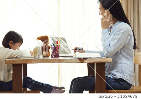 リビングで仕事する母の向かいでお絵かきをする娘 リビングで仕事する母の向かいでお絵かきをする娘 51054678