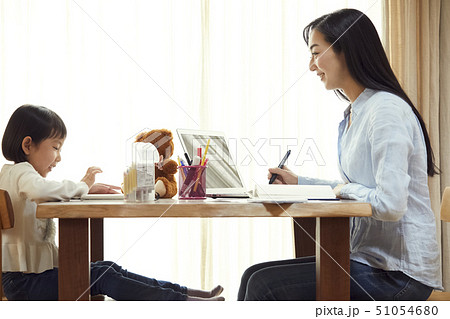 リビングで仕事する母の向かいでお絵かきをする娘 51054680