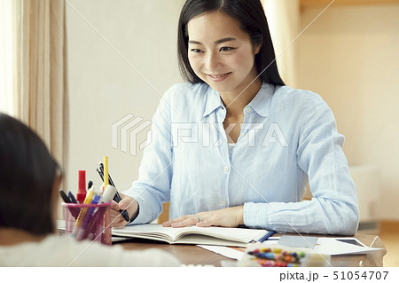 お絵かきをする娘を眺めながら仕事をする母親 お絵かきをする娘を眺めながら仕事をする母親 51054707