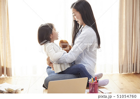 リビングの床で娘を抱っこする母親 リビングの床で娘を抱っこする母親 51054760