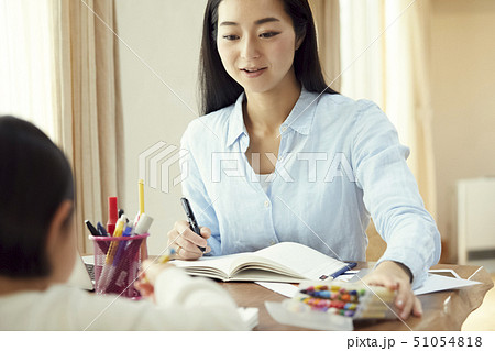 お絵かきをする娘を眺めながら仕事をする母親 お絵かきをする娘を眺めながら仕事をする母親 51054818