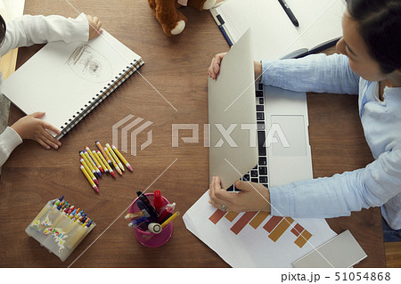 リビングで仕事する母の向かいでお絵かきをする娘の俯瞰 51054868